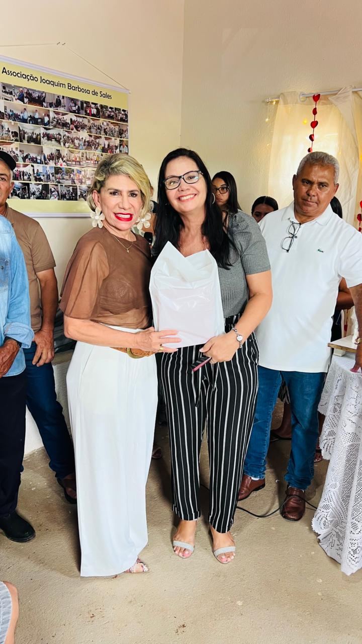 Associadas na sede, diante do painel de registros da associação.